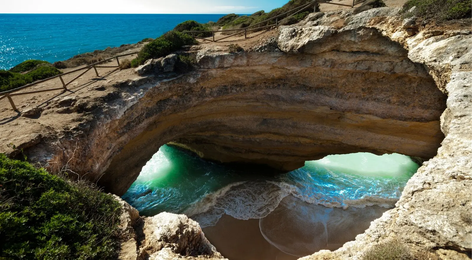 A sea arch and turquoise water on the golden Algarve coast near Praia da Marinha