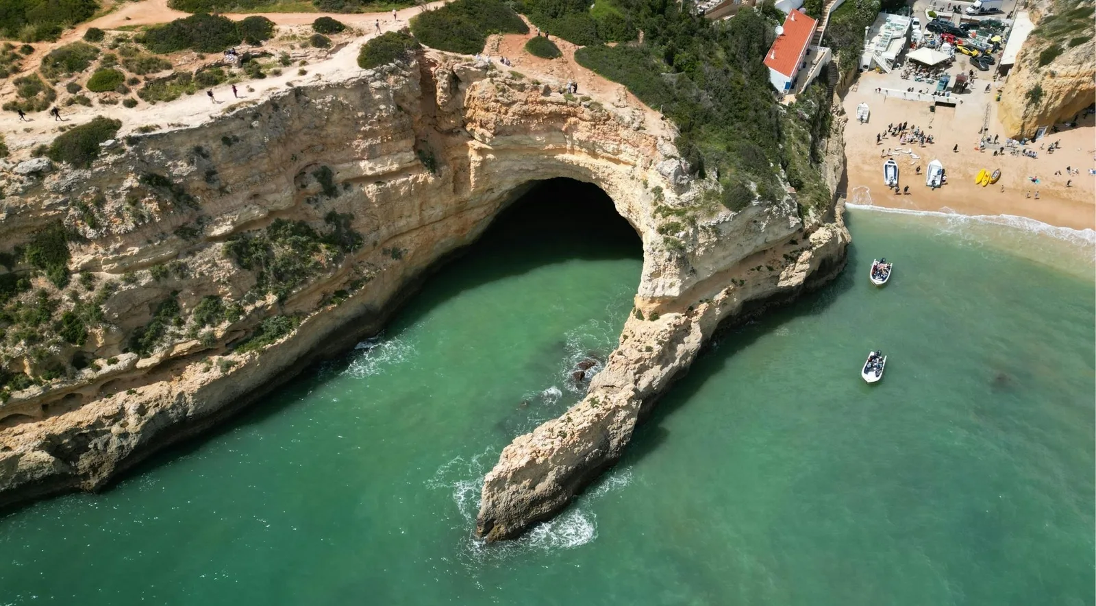 An aerial view of a golden Algarve cove and turquoise water on the coast near Albufeira