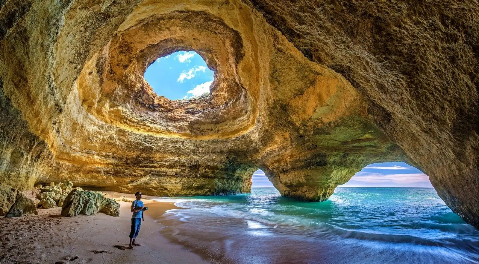 The twin arched entrances of Benagil Cave framing the golden interior, the destination of Lagos boat tours sailing 11 nautical miles east along the Algarve coast