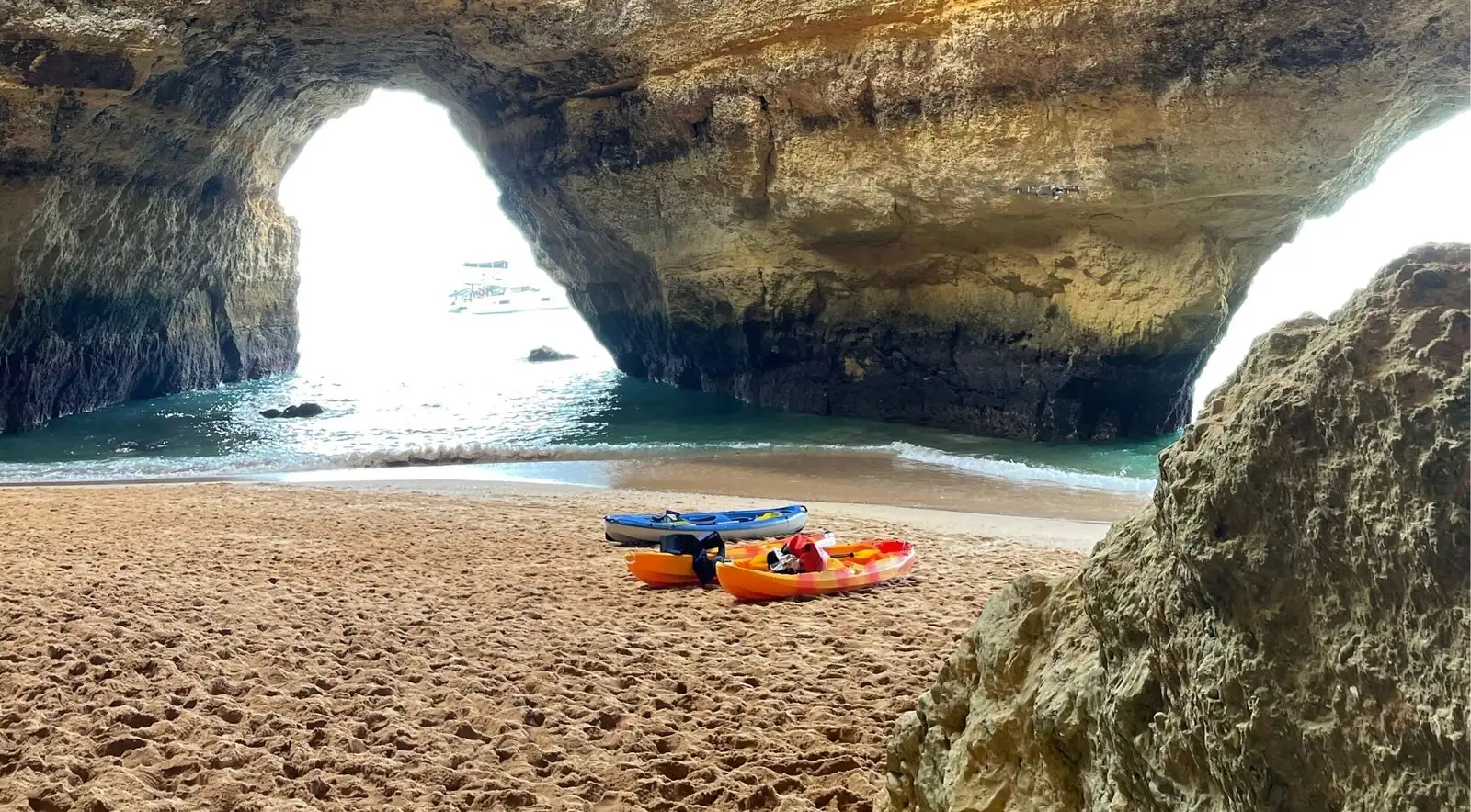 Guided kayaks inside Benagil Cave looking up at the round skylight dome on a clear Algarve morning